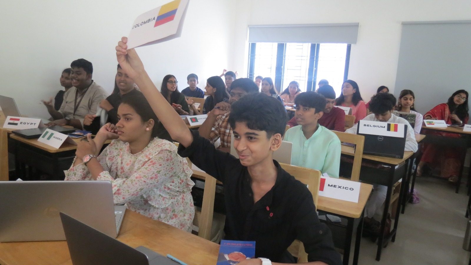 The delegate for Colombia raises a placard during a vote in a full committee room.