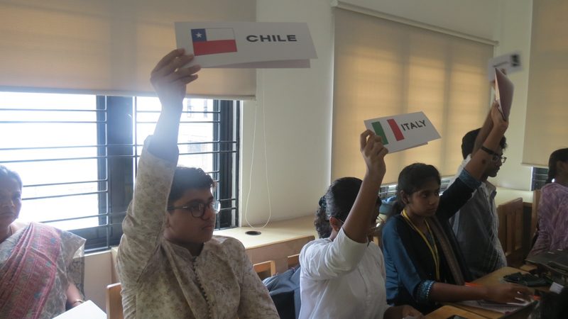 Delegates for Chile and Italy raise their placards to be recognised.